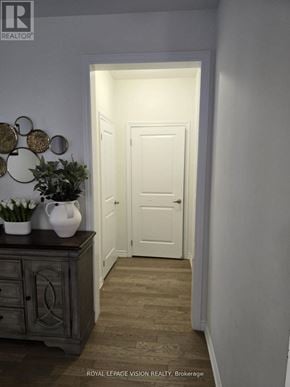 Whitby (Rolling Acres) apartment for rent - A hallway with a door at the end and a cabinet with plants on top.