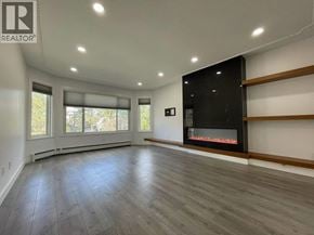 Vancouver apartment for rent - A spacious room with a fireplace and wooden flooring.