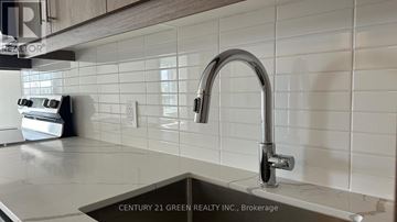 Kitchener condo for rent - A kitchen sink with a chrome faucet and a tiled wall.