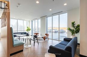 Kitchener condo for rent - A modern living room with a view of the parking lot outside.