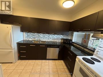Toronto (Agincourt South-Malvern West) condo for rent - A kitchen with black cabinets and a white stove top oven.