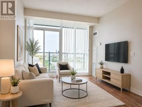 Mississauga (City Centre) condo for rent - A living room with a couch, a chair, a coffee table, and a flat-screen TV mounted on the wall.