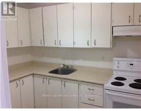 Ottawa house for rent - A kitchen with white cabinets and a white stove top oven.