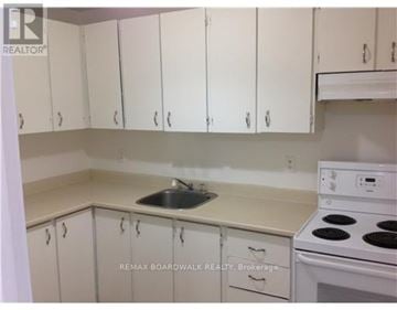 Ottawa house for rent - A kitchen with white cabinets and a white stove top oven.