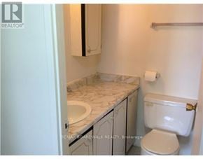 Ottawa house for rent - A bathroom with a toilet, sink, and cabinet.
