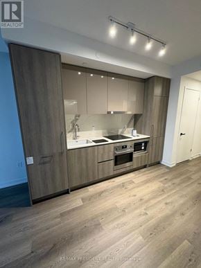 Vaughan (Vaughan Corporate Centre) condo for rent - A modern kitchen with wooden floors and cabinets.