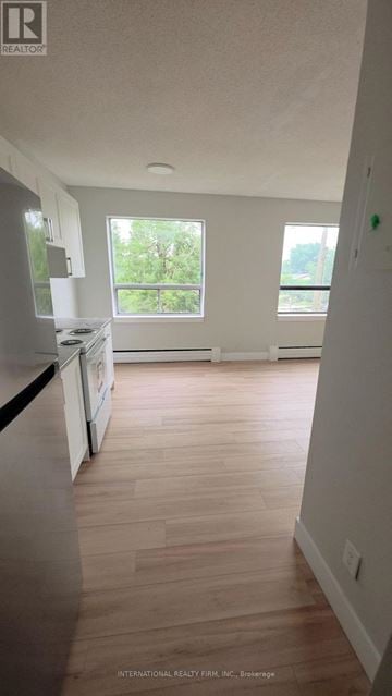 Hamilton (Mcquesten) multi-family for rent - A kitchen with white cabinets and a wooden floor.