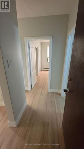 Hamilton (Mcquesten) multi-family for rent - A hallway with wood floors and white walls.