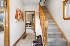 Guelph (Junction/Onward Willow) apartment for rent - A hallway with a staircase and a painting of flowers on the wall.