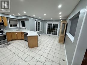 Oshawa (Pinecrest) apartment for rent - A kitchen with a tile floor and a large island in the middle.