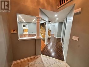 Oshawa (Pinecrest) apartment for rent - A hallway with a wooden floor and a staircase with a yellow railing.