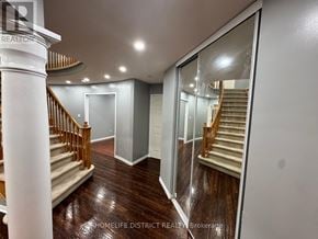 Oshawa (Pinecrest) apartment for rent - A spacious hallway with a wooden floor and a staircase with a wooden railing.