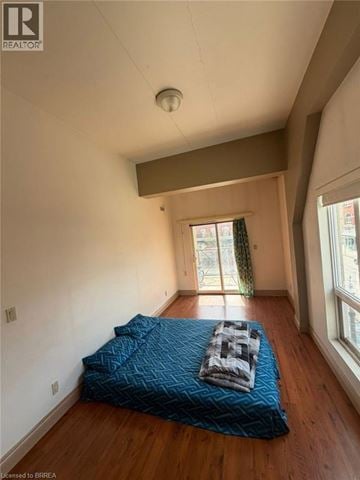Brantford condo for rent - A bedroom with a bed covered in a blue blanket.