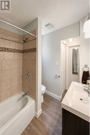 London East (East G) multi-family for rent - A bathroom with a tub, toilet, and sink.