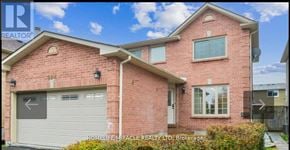 Ajax (Central West) apartment for rent - A red brick house with a white garage door and a window on the front.