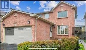 Ajax (Central West) apartment for rent - A brick house with a garage door and a sign that says "REALTOR".