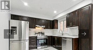 Ajax (Central West) apartment for rent - A kitchen with dark wood cabinets and a stainless steel refrigerator.