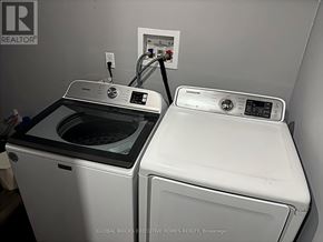 Burlington (Palmer) apartment for rent - A Global Bricks Executive Homes Realty brochure is displayed on a wall above a washer and dryer.