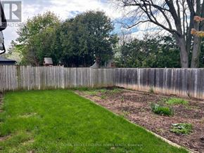 Burlington (Palmer) apartment for rent - A backyard with a wooden fence and a green lawn.