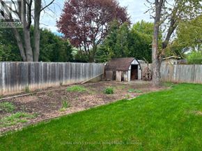Burlington (Palmer) apartment for rent - A backyard with a wooden fence and a small shed.