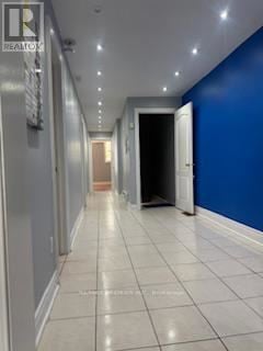 Toronto (Dovercourt-Wallace Emerson-Junction) apartment for rent - A long hallway with white tile floors and blue walls.