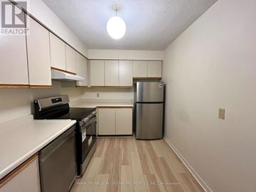 Ottawa condo for rent - A kitchen with white cabinets and a stainless steel refrigerator.