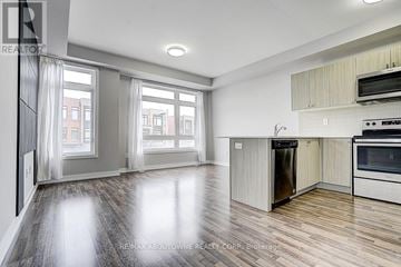 Vaughan (Vaughan Grove) townhouse for rent - A spacious kitchen with a refrigerator, oven, and microwave.