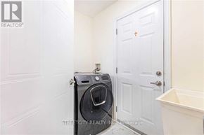 London North (North C) apartment for rent - A washing machine is placed next to a white door in a small room.