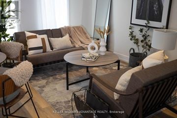 Toronto (Rockcliffe-Smythe) multi-family for rent - A living room with a brown couch, a coffee table, and a chair with a white cushion.