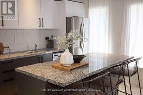 Toronto (Rockcliffe-Smythe) multi-family for rent - A kitchen with granite countertops and a vase of flowers on a cutting board.