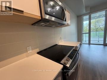 Toronto (Parkwoods-Donalda) condo for rent - A kitchen with a stove top oven and microwave above it.