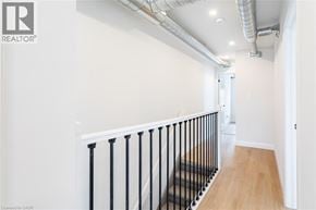 Hamilton apartment for rent - A hallway with a black railing and wooden floors.