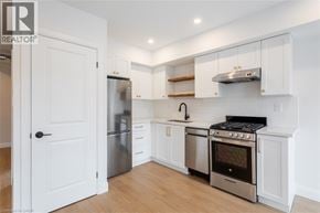 Hamilton apartment for rent - A white kitchen with a refrigerator, oven, and stove.