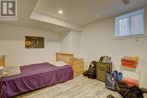 Brampton (Credit Valley) apartment for rent - A bedroom with a purple bedspread and a wooden bed frame.