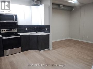 Peterborough (Town Ward 3) condo for rent - A kitchen with a stove top oven and a microwave.