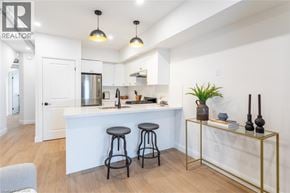 Hamilton apartment for rent - A white kitchen with a bar area and two stools.