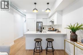 Hamilton apartment for rent - A white kitchen with a bar and two stools.