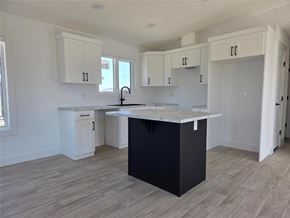 Mitchell apartment for rent - A kitchen with a black island and white cabinets.