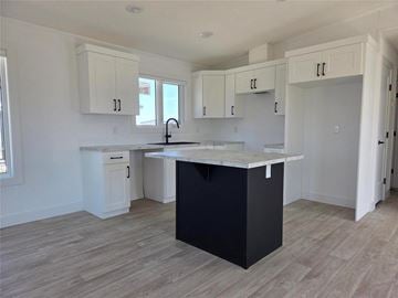 Mitchell apartment for rent - A kitchen with a black island and white cabinets.