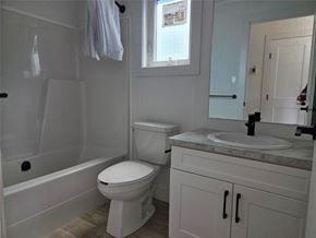 Mitchell apartment for rent - A white toilet in a bathroom with a white cabinet and a white sink.