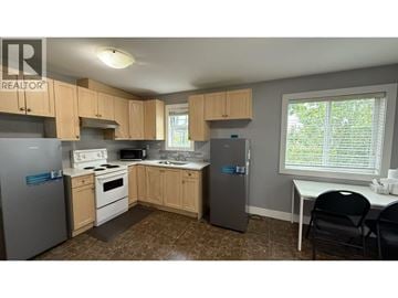 Burnaby apartment for rent - A kitchen with wooden cabinets and a refrigerator.