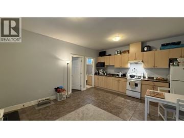 Burnaby apartment for rent - A kitchen with a white refrigerator and wooden cabinets.