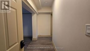 Toronto (Downsview-Roding-Cfb) apartment for rent - A hallway with a door on the left and a wall-mounted light switch on the right.