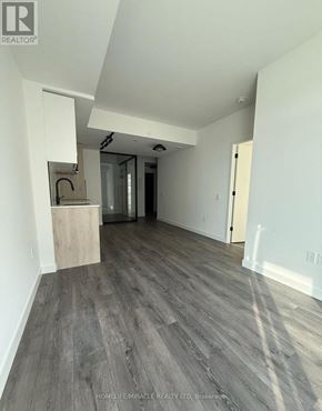 Toronto (Centennial Scarborough) condo for rent - A room with wooden flooring and white walls, with a kitchen island in the middle.