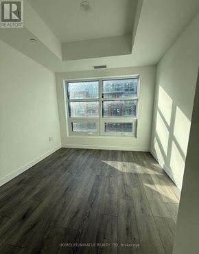 Toronto (Centennial Scarborough) condo for rent - A room with a large window and wooden flooring.