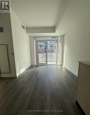 Toronto (Centennial Scarborough) condo for rent - A room with wooden floors and a glass door leading to a balcony.