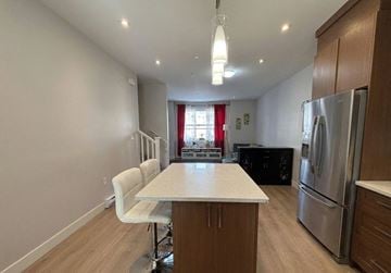 Langley townhouse for rent - A kitchen with a table and chairs in the middle of the room.
