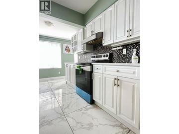 North Vancouver apartment for rent - A kitchen with white cabinets and a black and white tiled backsplash.