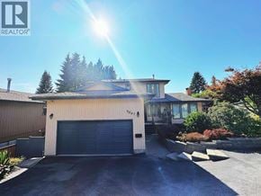 North Vancouver apartment for rent - A house with a garage and a driveway in front of it.