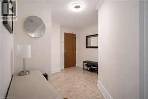 Hamilton condo for rent - A hallway with a lamp, mirror, and bench.